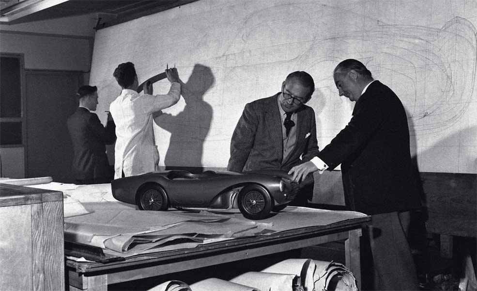 Le propriétaire d’Aston Martin, David Brown (à gauche), inspecte le modèle en argile d’une Aston Martin avec Frank Feeley, le designer de la marque, au studio de design Feltham, en 1954. © Popperfoto via Getty Images/Getty Images